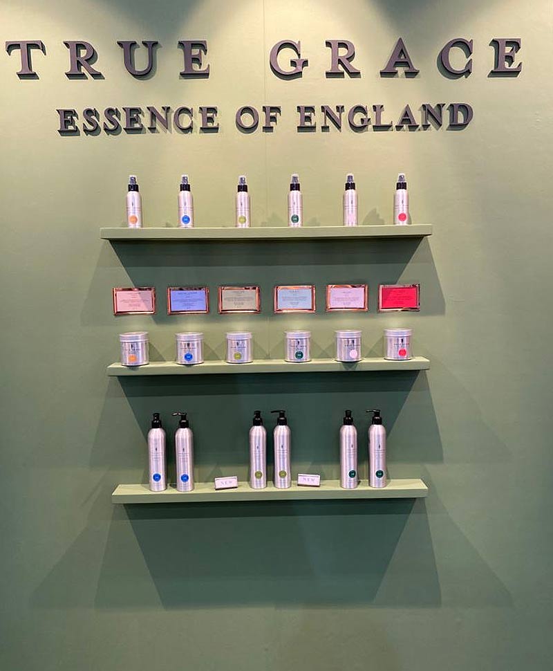 Einige Produkte der Marke True Grace - Essence of England stehen fein säuberlich geordnet in Regalen an der Wand