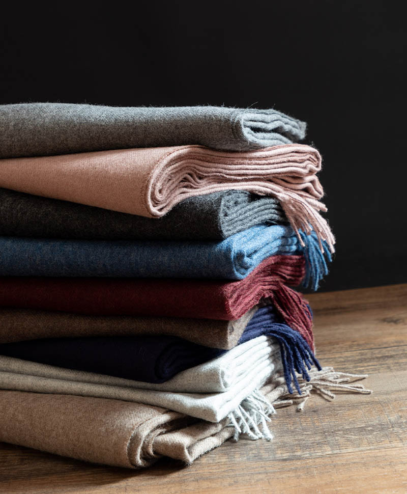 Ein Stapel Wolldecken von Christian Fischbacher in verschiedenen Farben