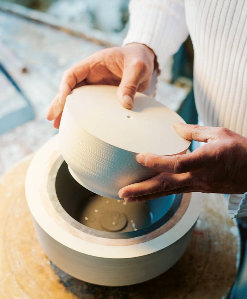 Zwei Hände arbeiten an einem Designer Porzellan von Fürstenberg