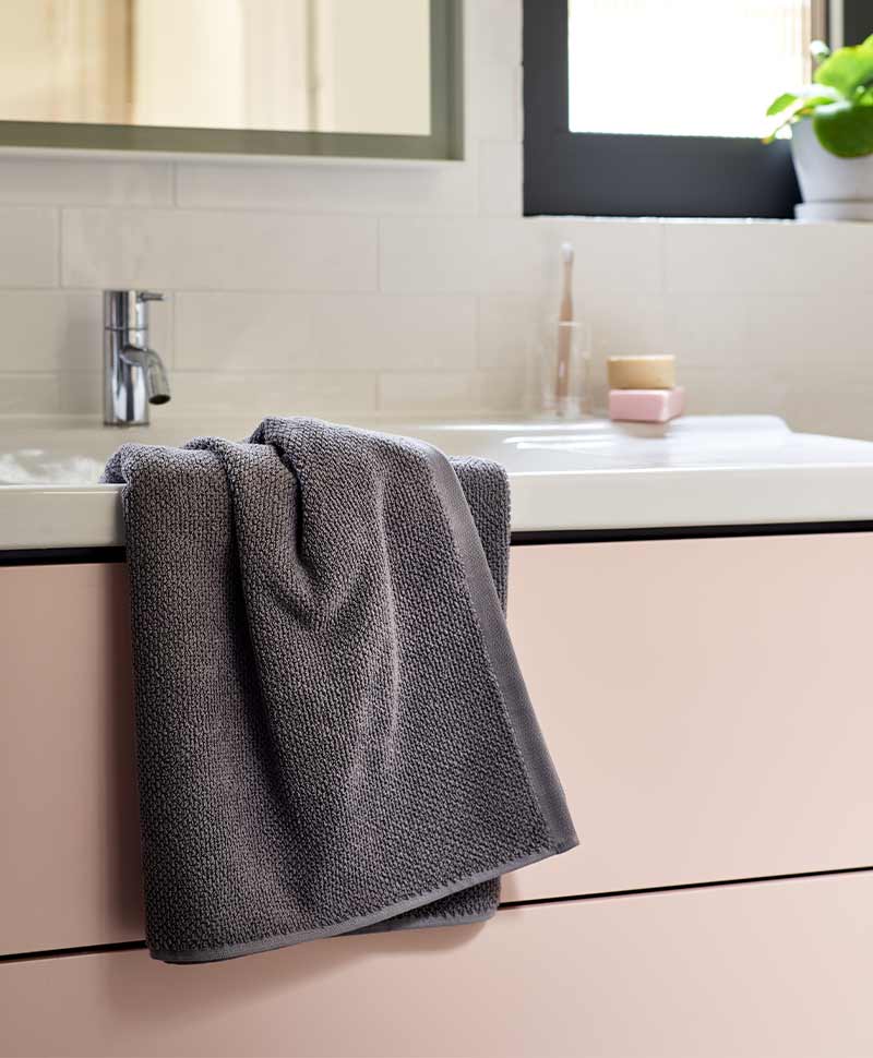 Anthrazitfarbenes Handtuch von Christy liegt an einem Waschbecken